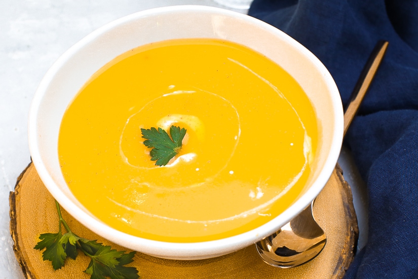 Instant Pot Butternut Squash Soup in white bowl garnished with cream and parsley