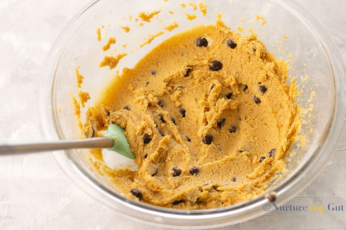 chocolate chip cookie batter in clear bowl with spatula